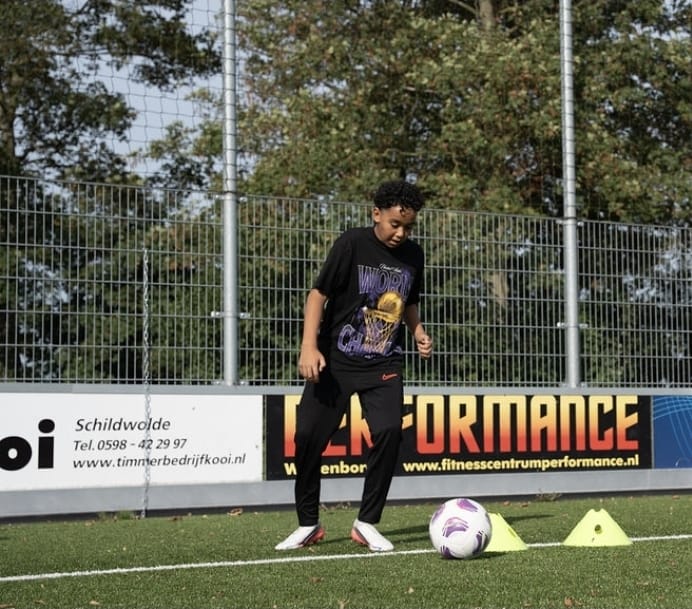 Speler dribbelt met de bal langs pionnen