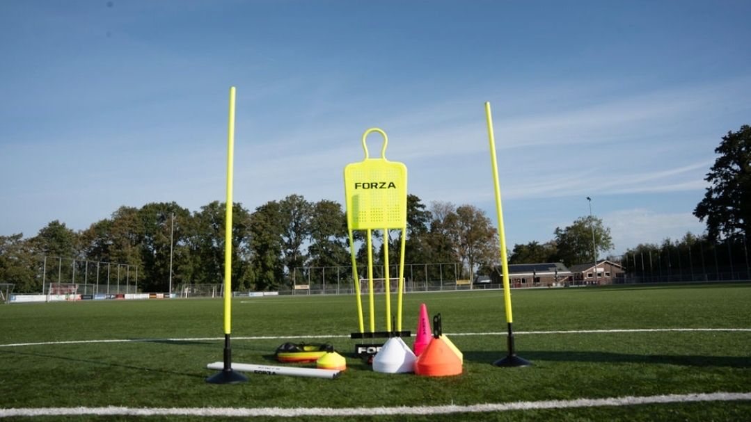 Trainingsmateriaal op het veld: pionnen, stokken en een stormram