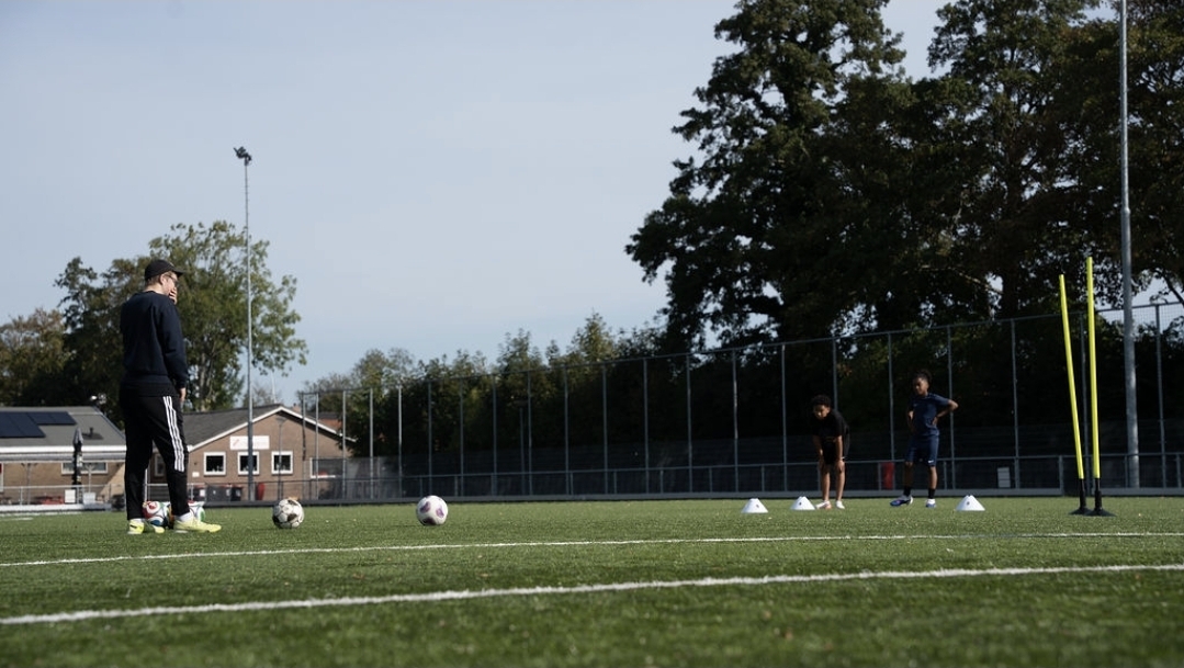 Olav geeft instructie aan twee spelers op het veld