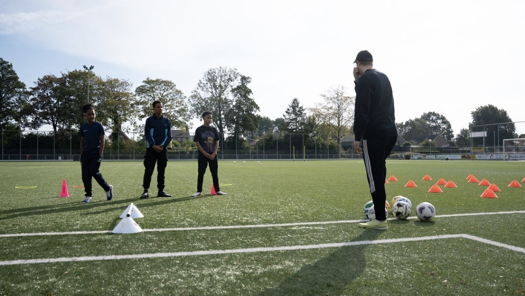 Olav legt een oefening uit aan een groepje spelers