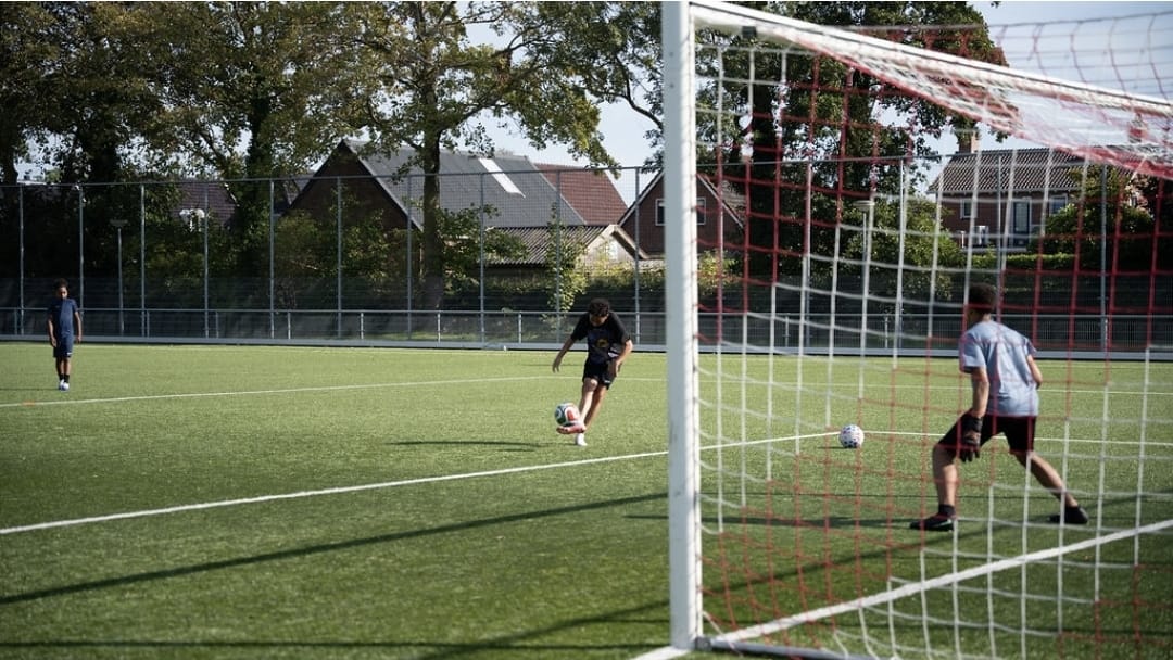 Speler schiet op doel met een keeper in het doel